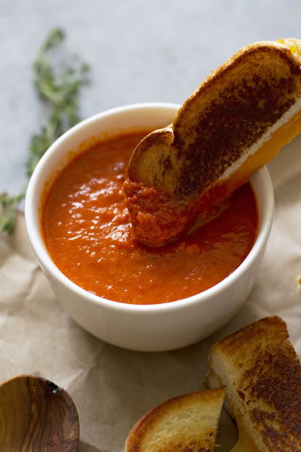 dipping grilled cheese into tomato soup