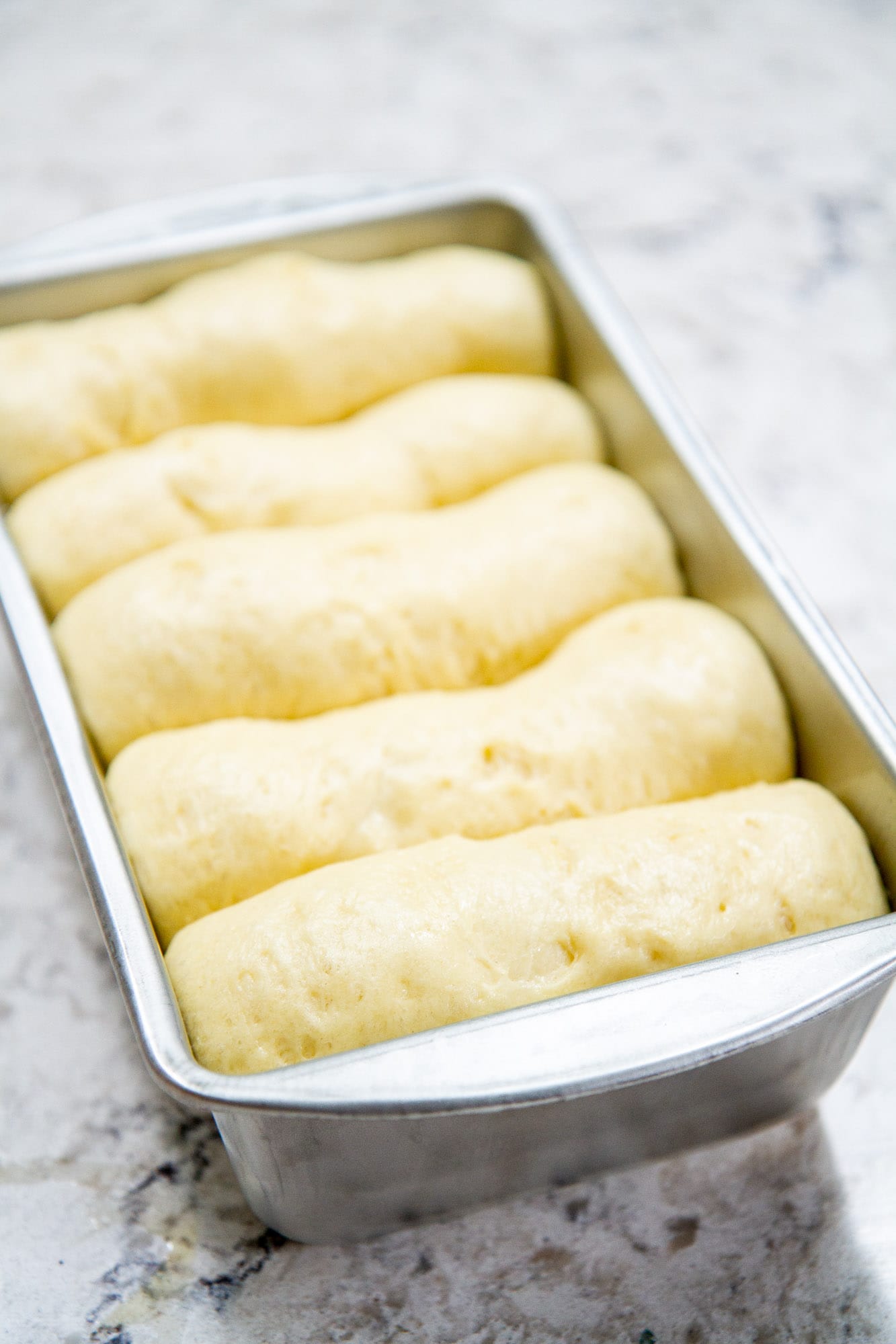risen classic brioche loaf bread in baking pan