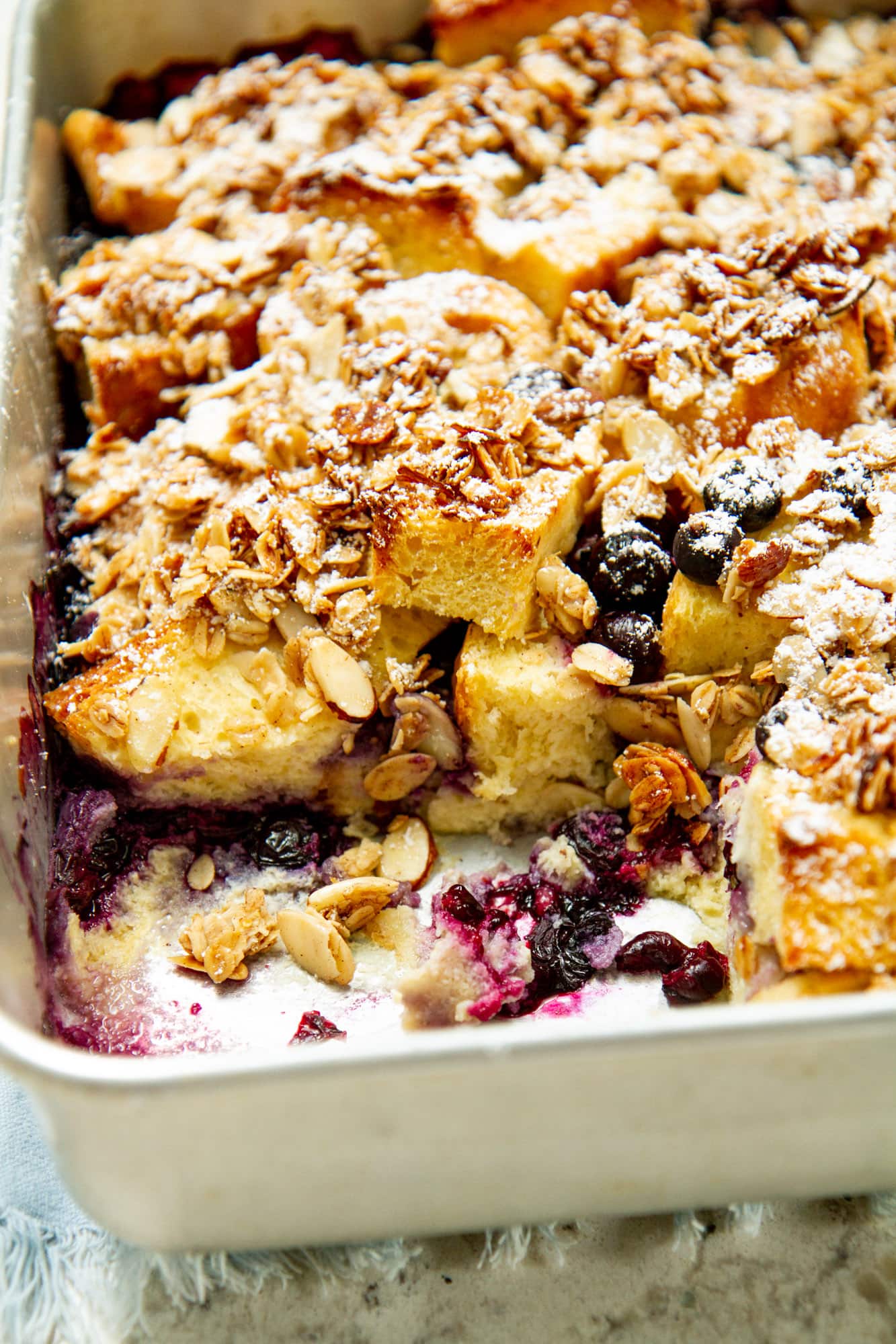 blueberry brioche french toast casserole close up in baking dish