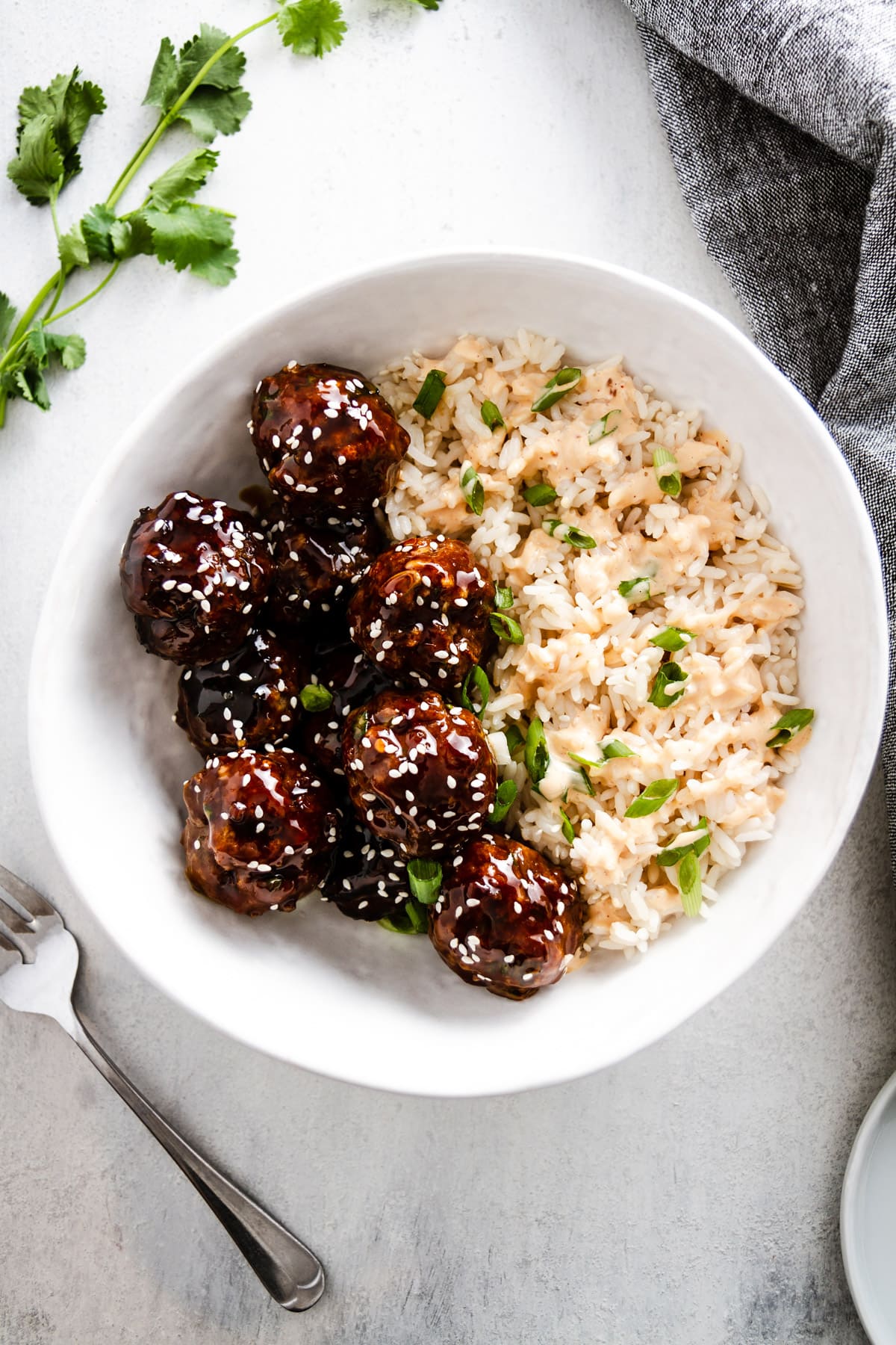 korean bbq meatballs in a bowl with rice with fork off to the side