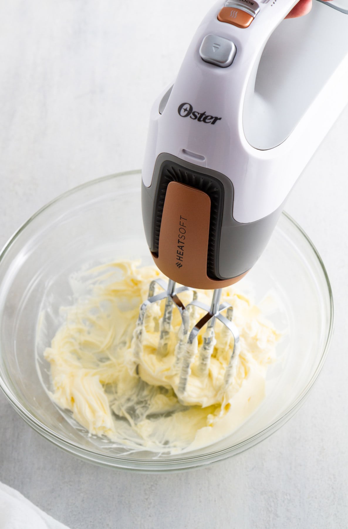 a hand mixer mixing butter in a bowl