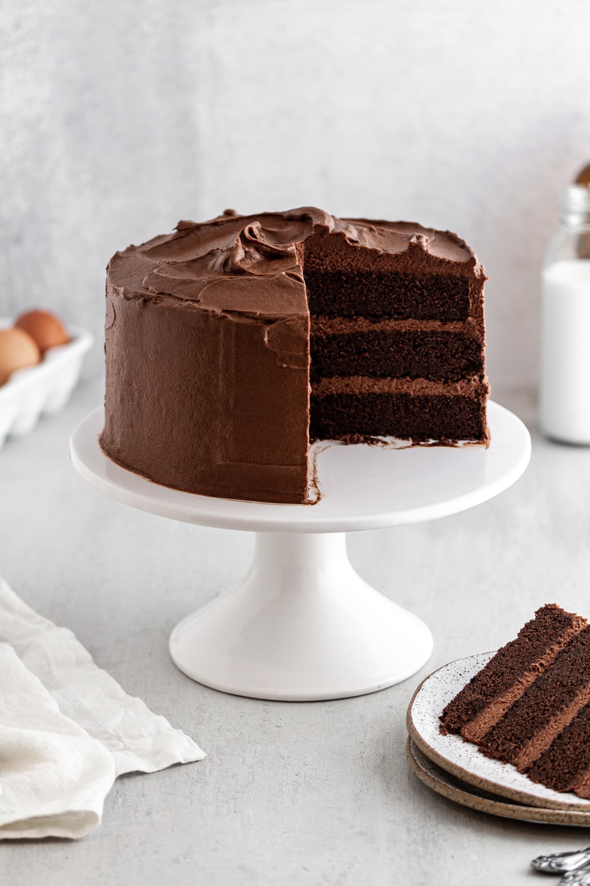 Devil's Food Cake on a cake stand with a slice taken out of it