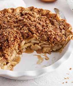 dutch caramel apple pie in a pie plate with a slice taken out