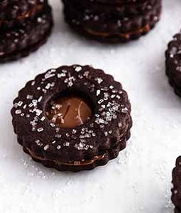 chocolate nutella linzer cookies stacked on a surface