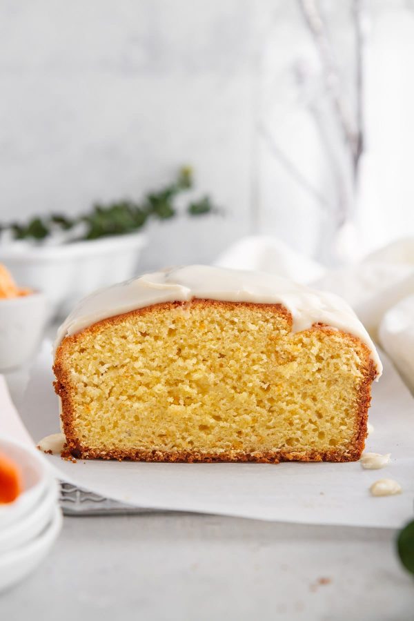 sliced iced clementine pound cake on parchment paper