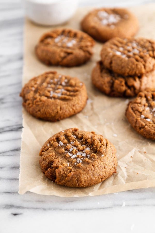 flourless almond butter cookies stacked on parchment paper