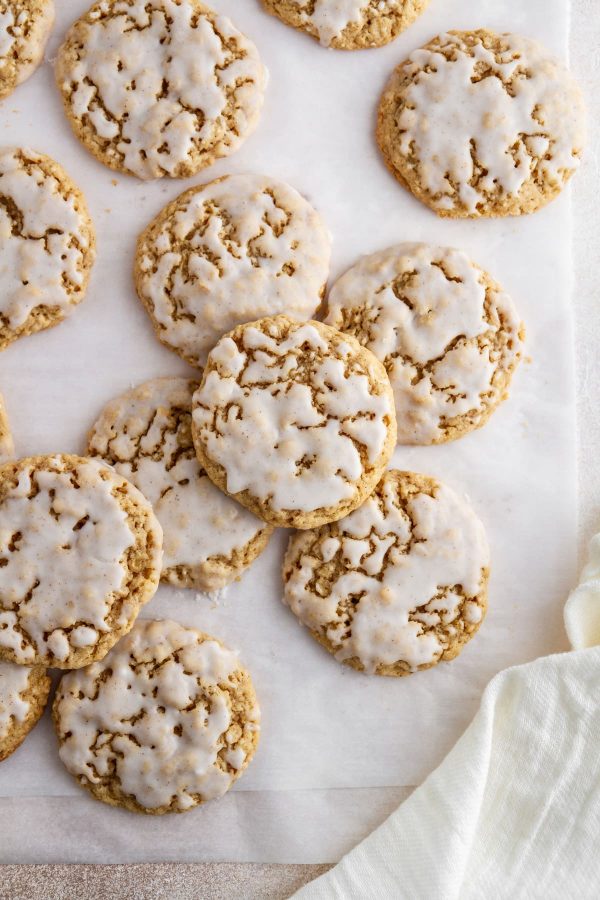 iced pumpkin spice oatmeal cookies on parchment paper
