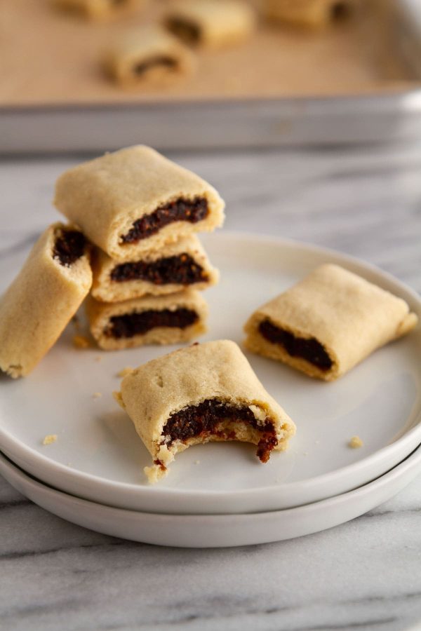 homemade fig newtons stacked on a plate with a bite taken out of one