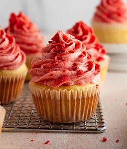 strawberry shortcake cupcakes on a cooling rack