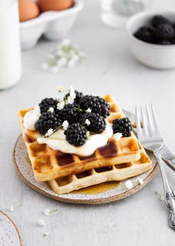 sourdough waffles with whipped cream and berries on a plate